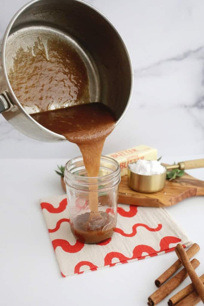 pouring hot buttered rum batter into jar