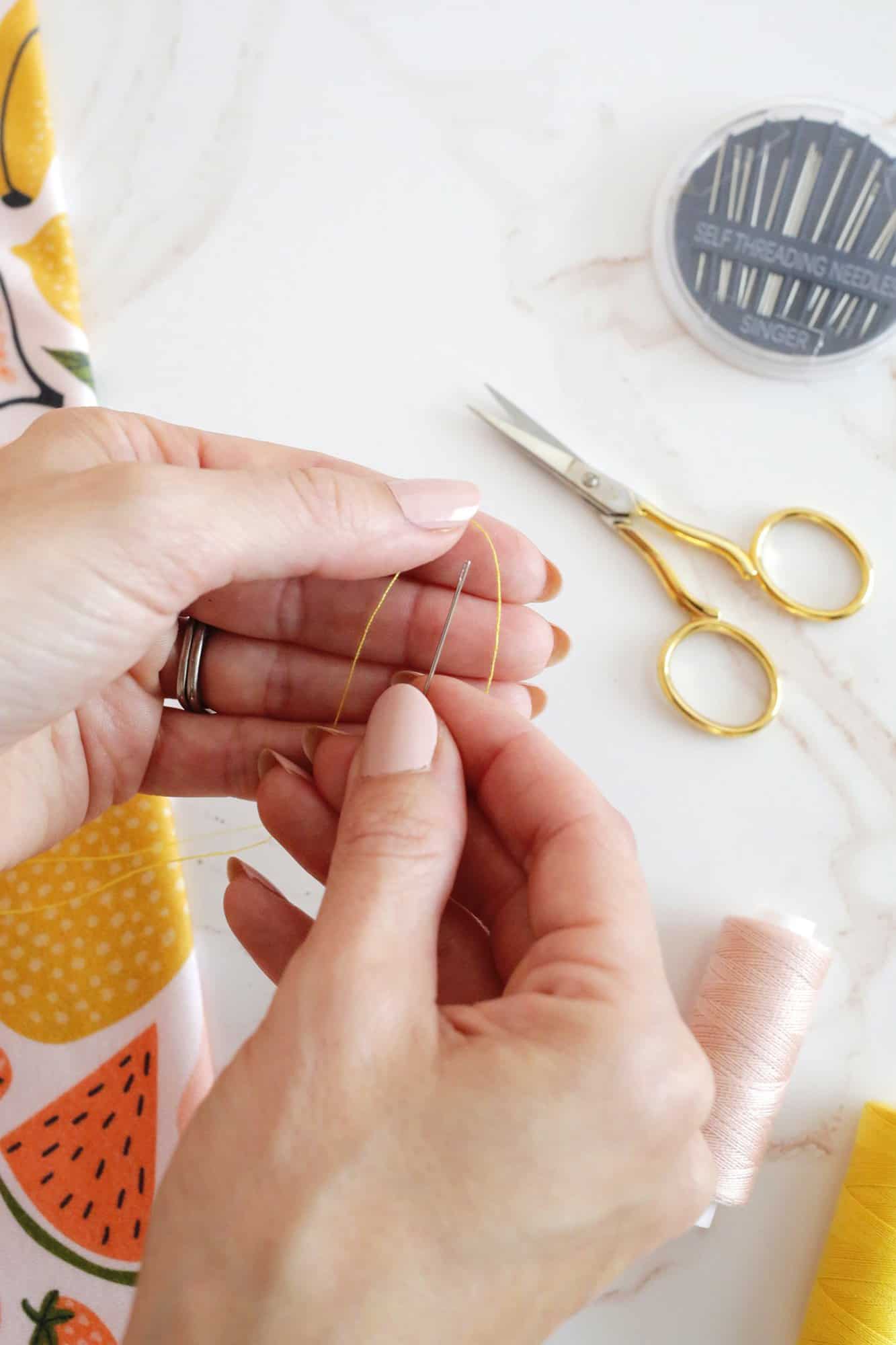 thread held above a self threading needle