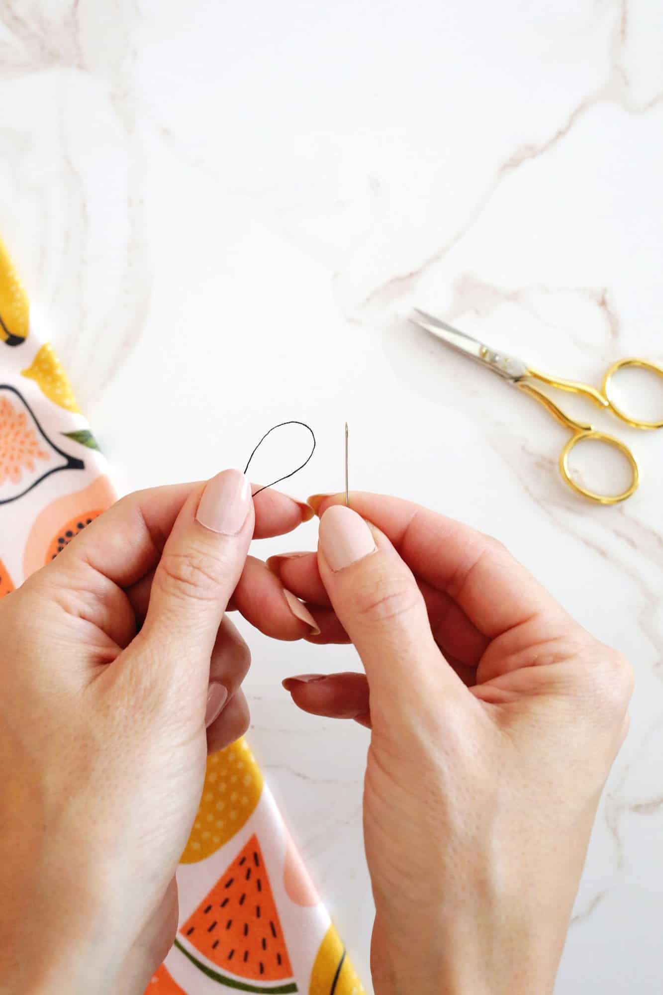 looped thread held next to a needle